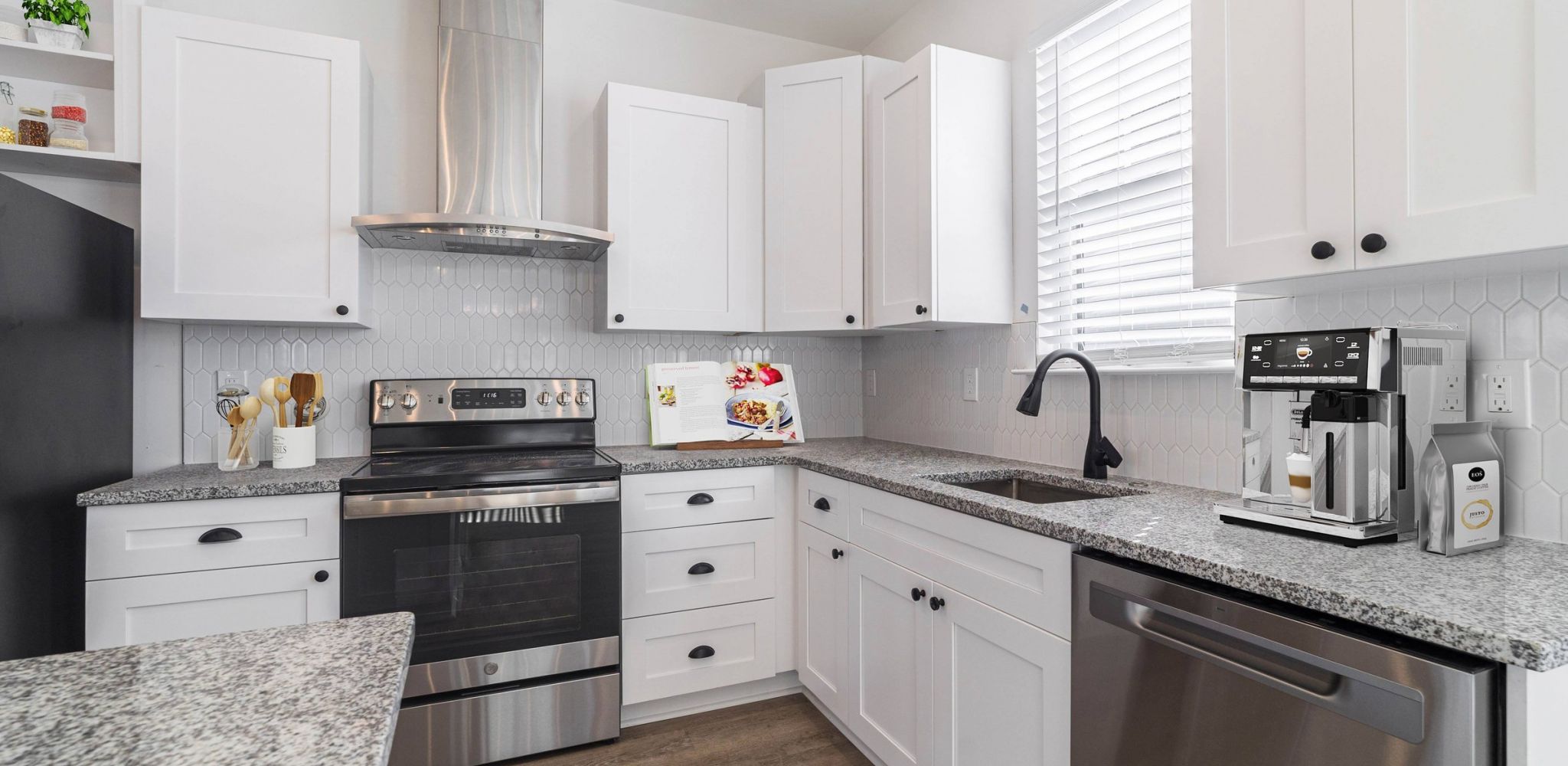 Hawthorne Cottages at Leland luxury home kitchen with island, designer tile backsplash, and stainless steel appliances